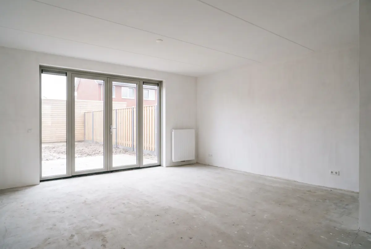 Een lege nieuwbouwwoonkamer zonder meubels